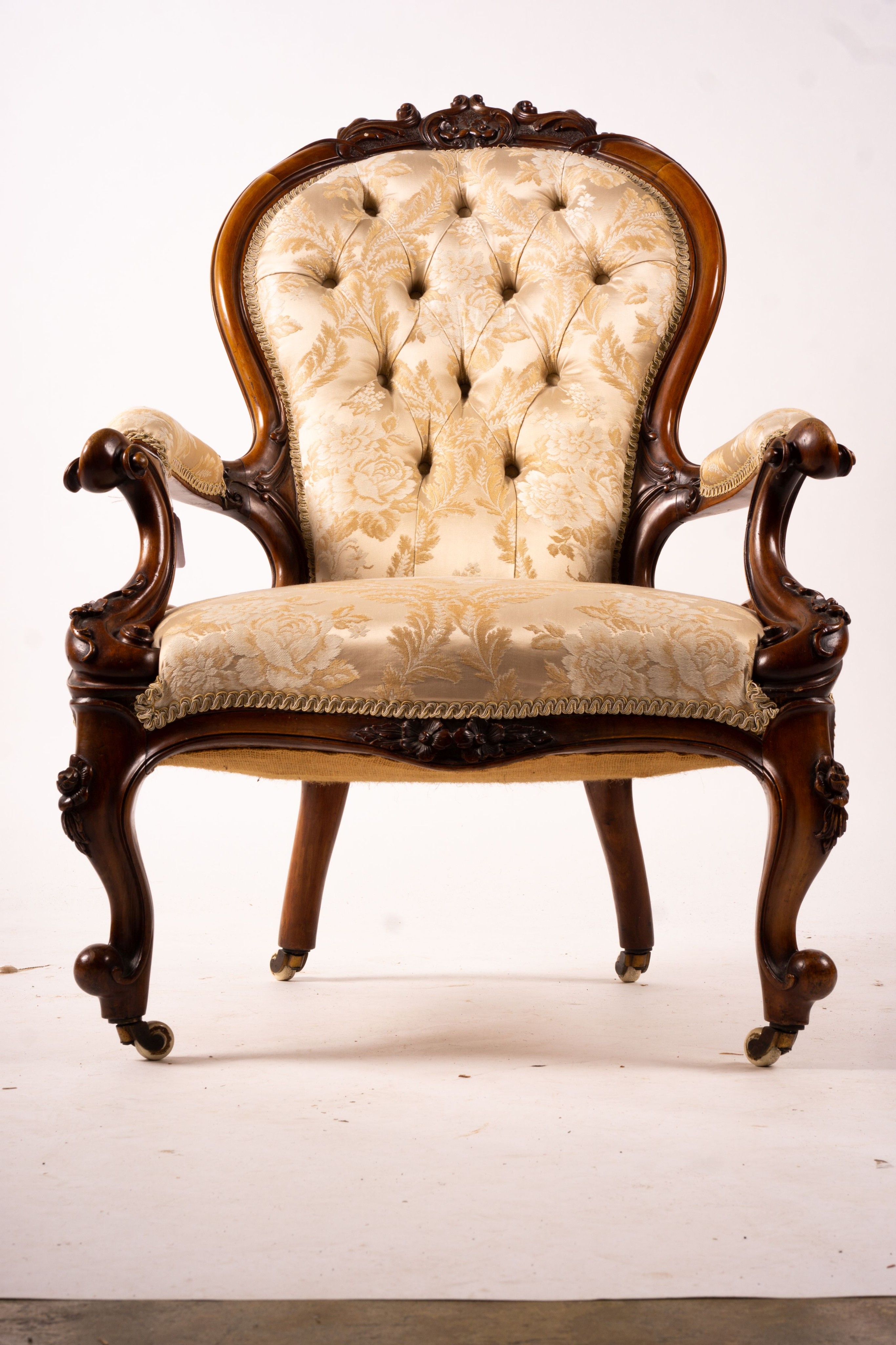 A late Victorian carved walnut three piece salon suite, comprising chaise longue, open armchair and nursing chair